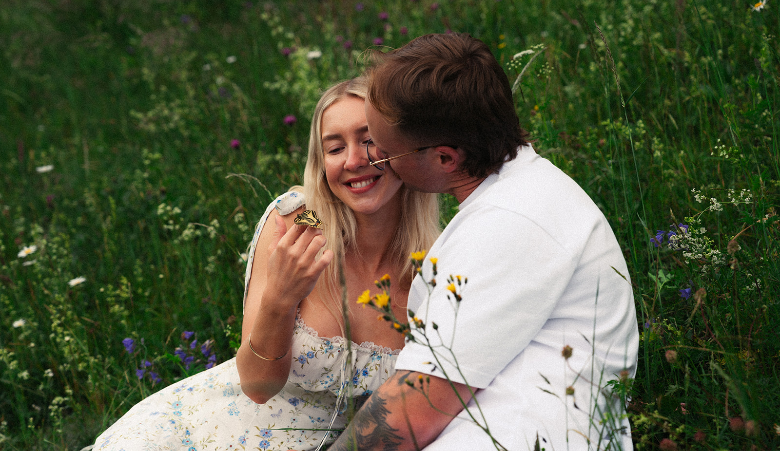 A cinematic photo of a couple with a butterfly near Wengen, Switzerland.