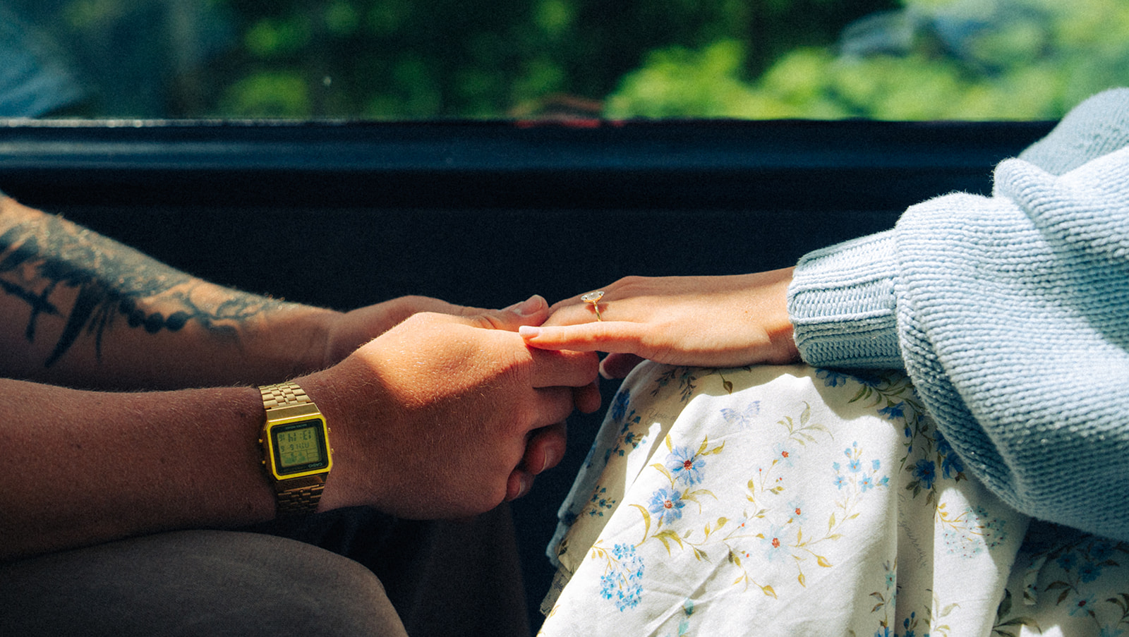 A cinematic detail shot of a couple's hands when they are holding each other in a train in Switzerland.