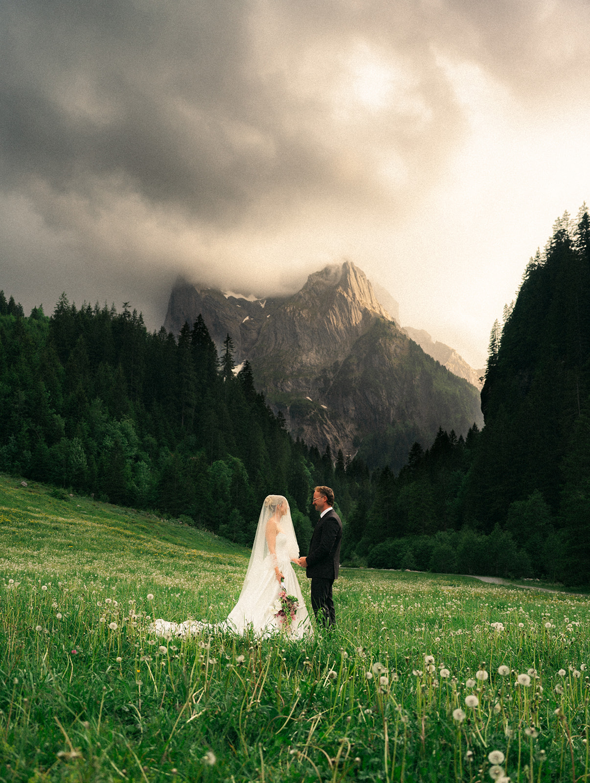 A cinematic photo of a bride and bridegroom during their elopement in Rosenlaui, Switzerland with the Swiss alps in the background.