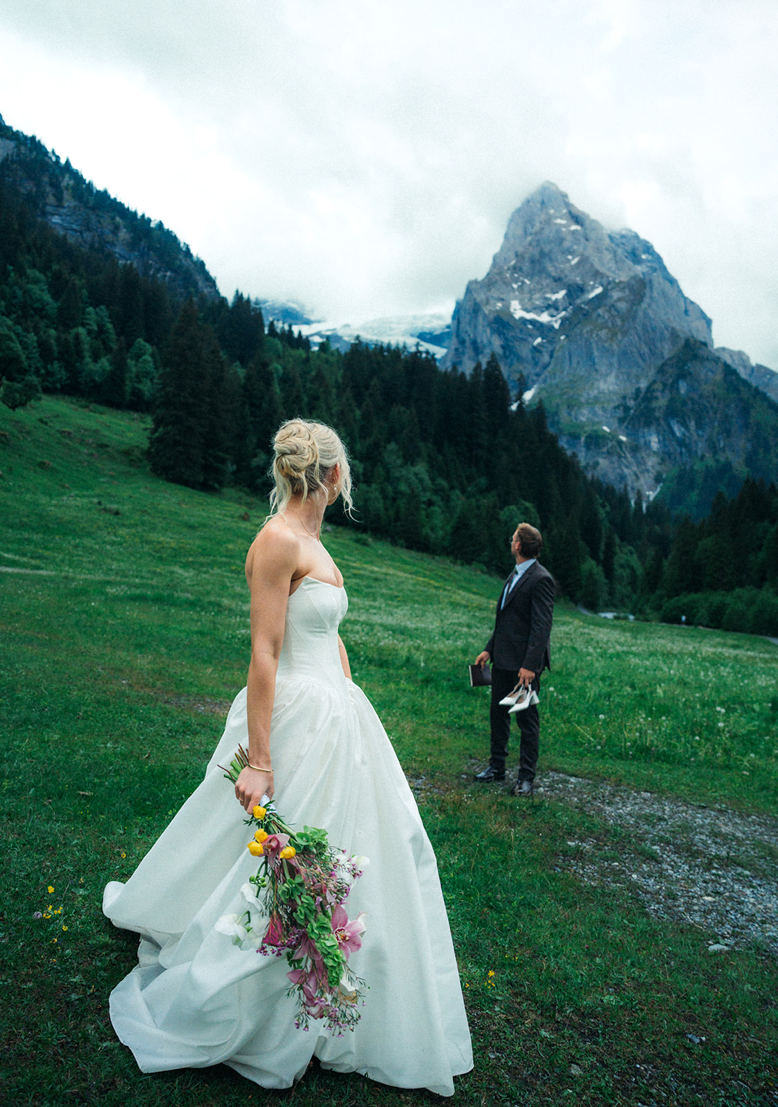 A cinematic photo of a bride and bridegroom during their elopement in Rosenlaui, Switzerland with the Swiss alps in the background.