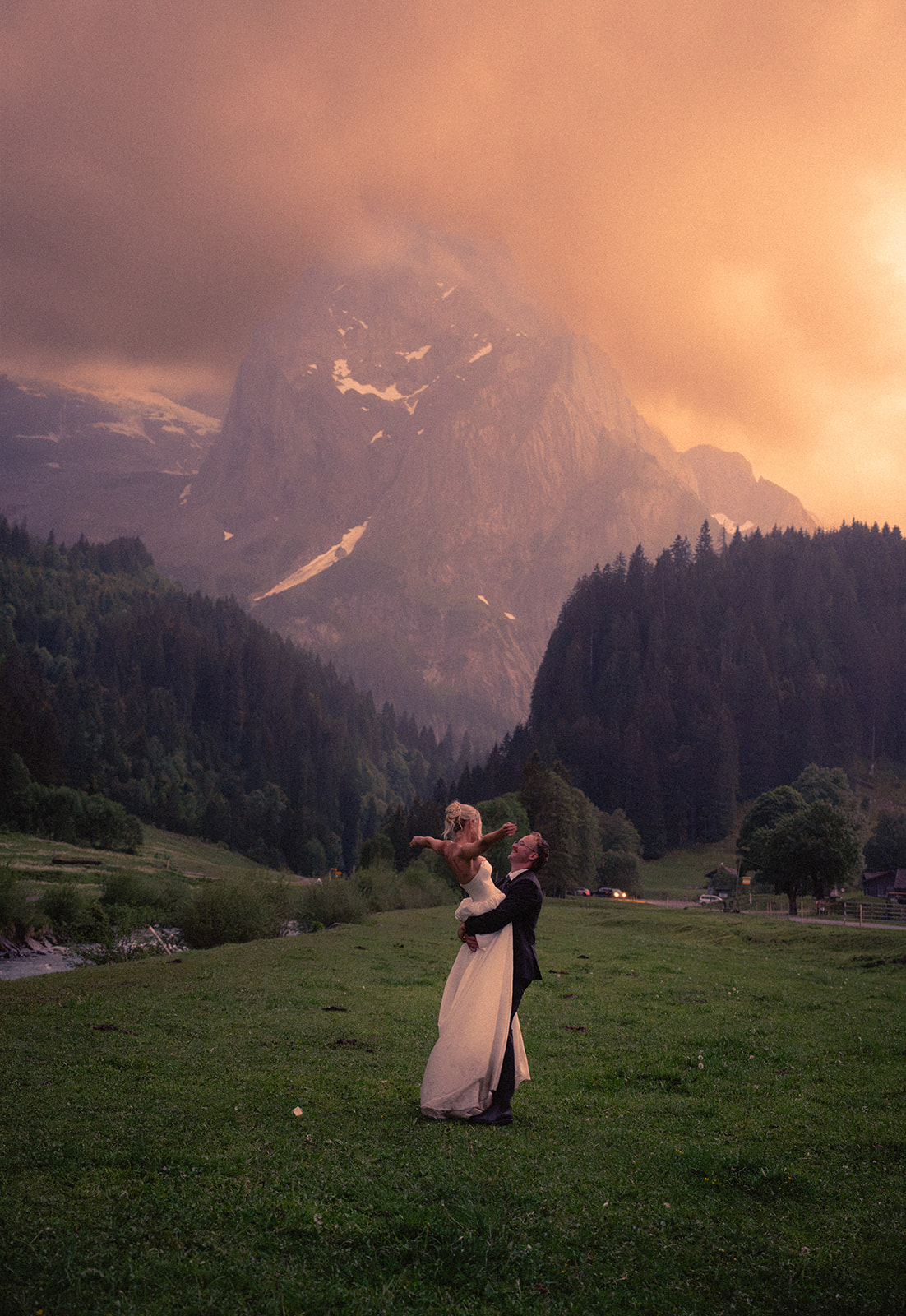 A cinematic photo of a bride and bridegroom dancing during their elopement in Rosenlaui, Switzerland with the Swiss alps in the background.